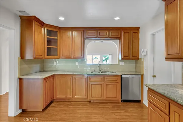 a kitchen with stainless steel appliances granite countertop wooden cabinets a sink and dishwasher
