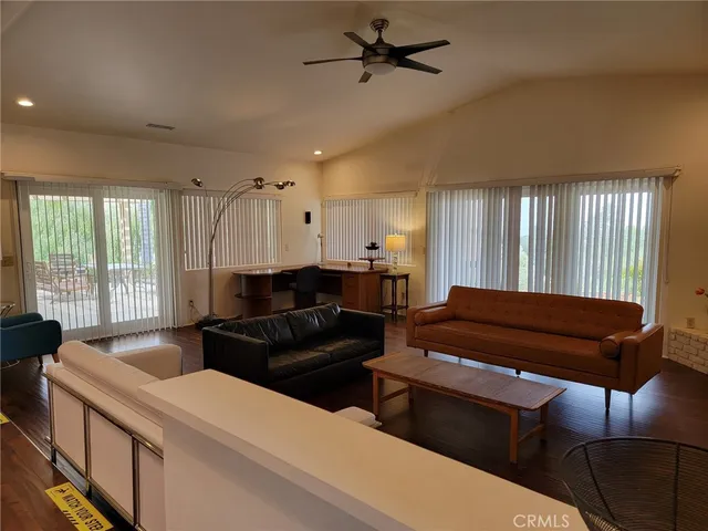 a living room with furniture a ceiling fan and a window
