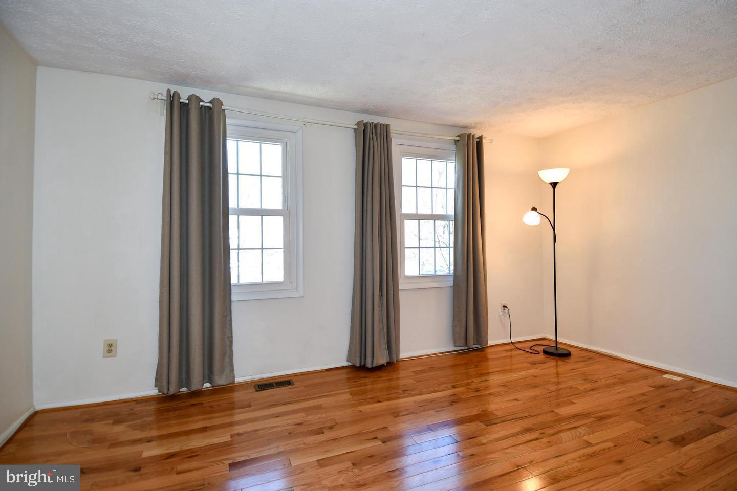 8417 Cedar Falls Court Springfield, VA 22153 - Photo 16 of 34 an empty room with wooden floor and windows