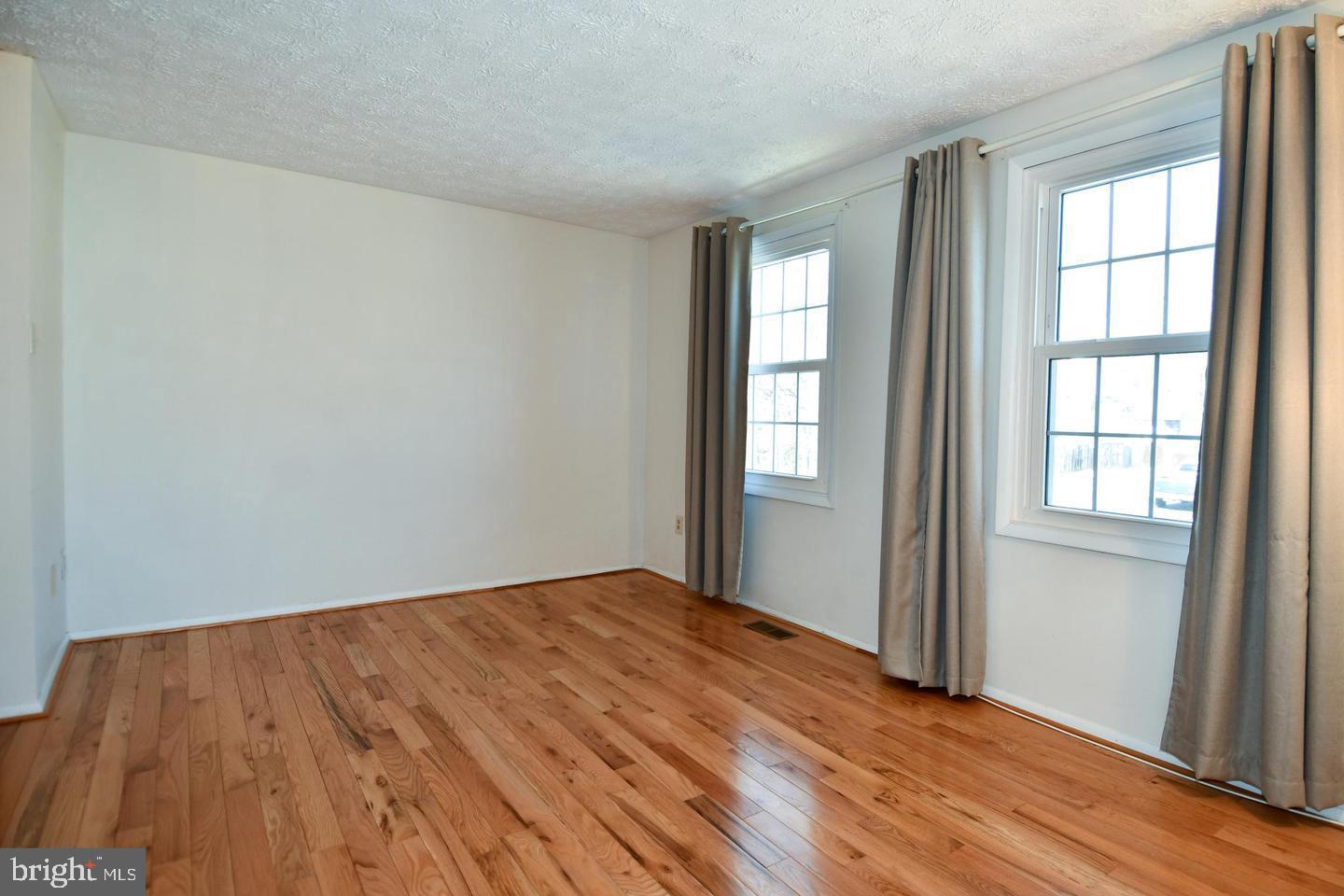 8417 Cedar Falls Court Springfield, VA 22153 - Photo 17 of 34 an empty room with wooden floor and windows