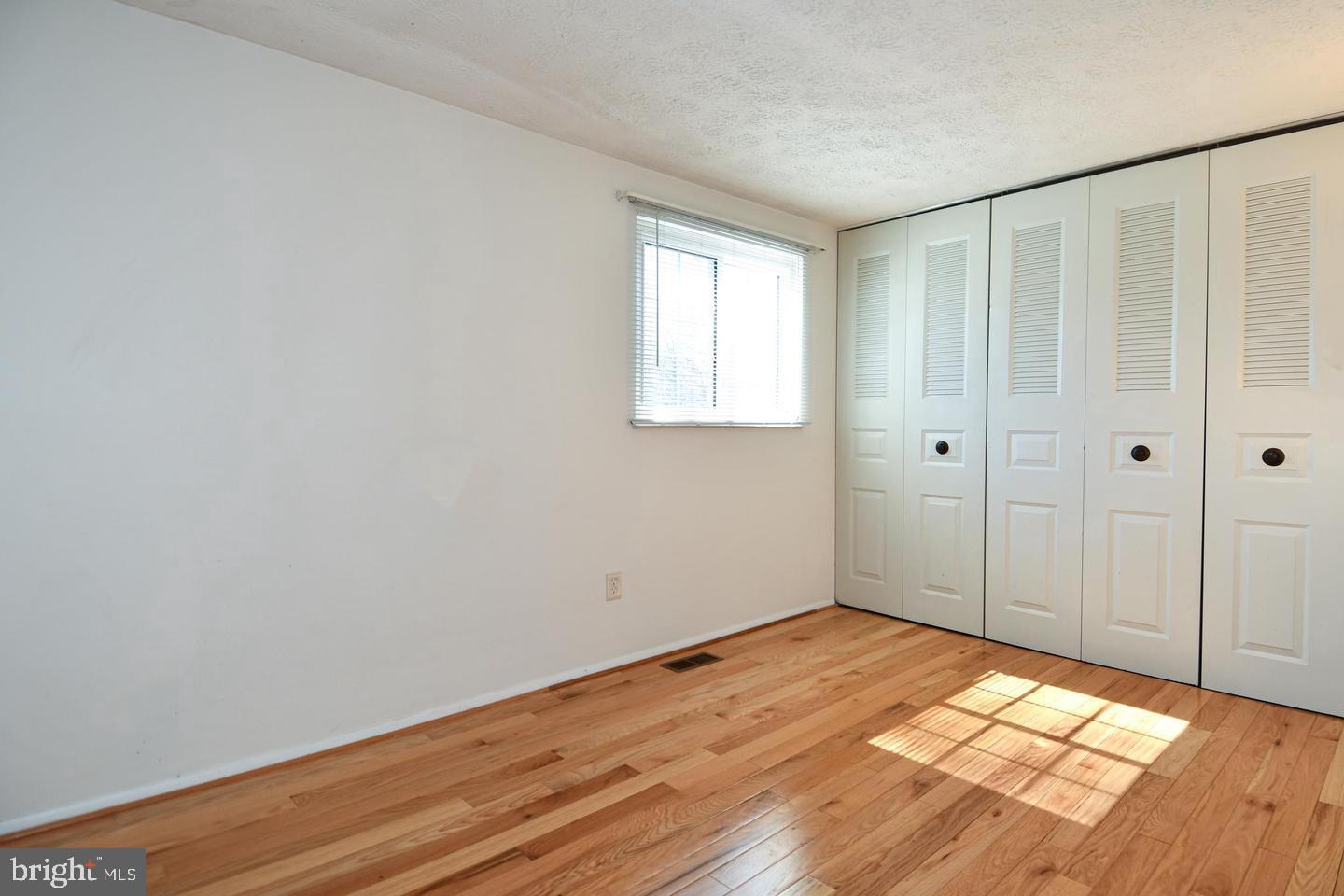 8417 Cedar Falls Court Springfield, VA 22153 - Photo 25 of 34 a view of an empty room with wooden floor and a window