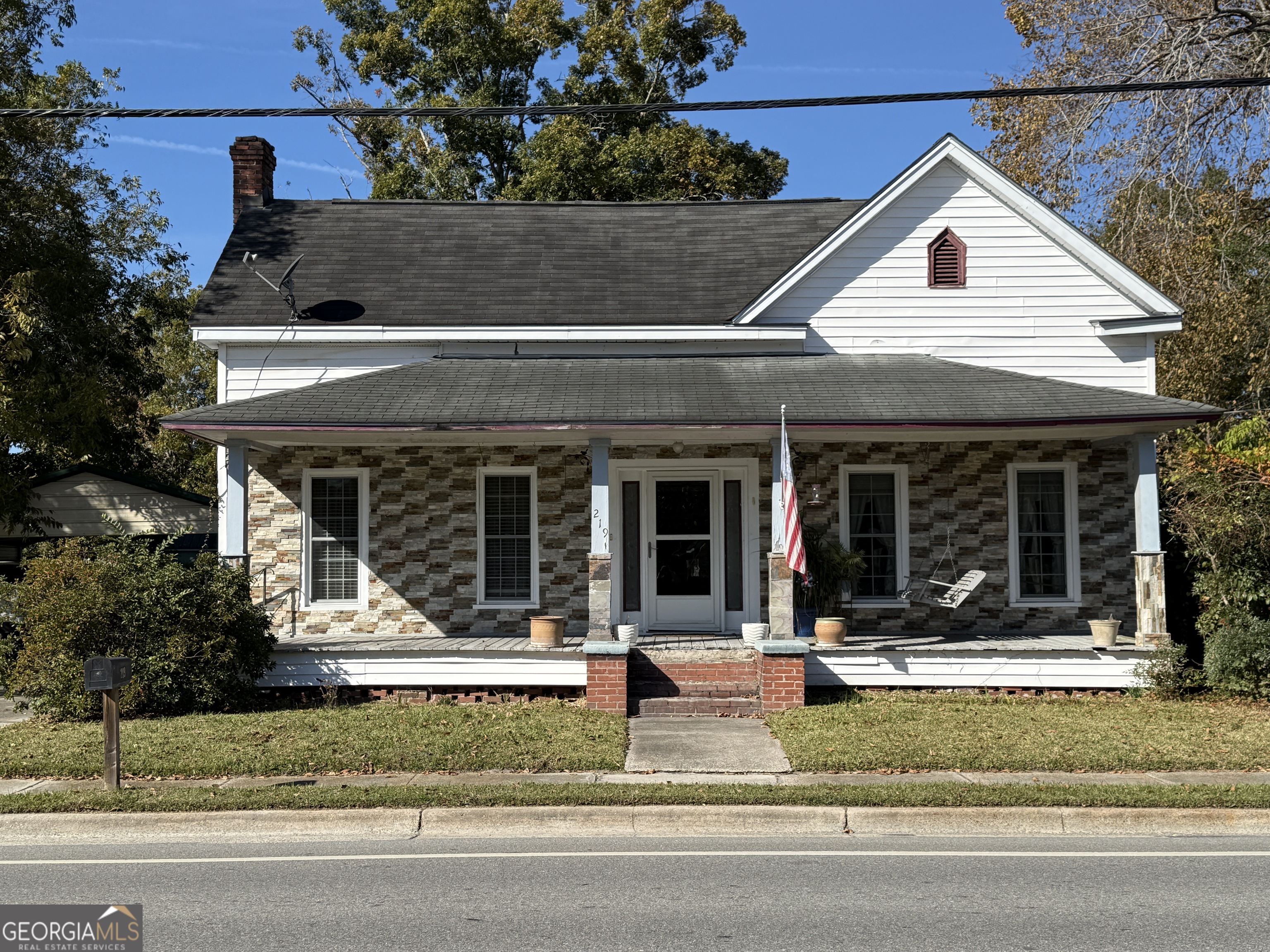 a front view of a house with a garden and plants