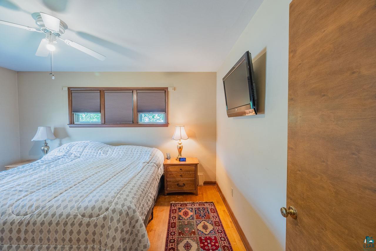 101 2nd Avenue North Biwabik, MN 55708 - Photo 13 of 44 Bright room featuring wood-finish flooring, a ceiling fan with integrated lighting, and three windows with blinds