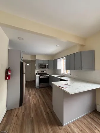 a kitchen with a refrigerator a stove and wooden floor