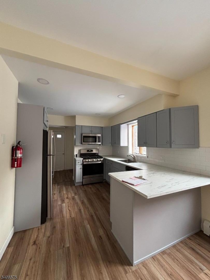 225 East Northfield Road Livingston, NJ 07039 - Photo 3 of 11 a kitchen with a refrigerator a stove and wooden floor