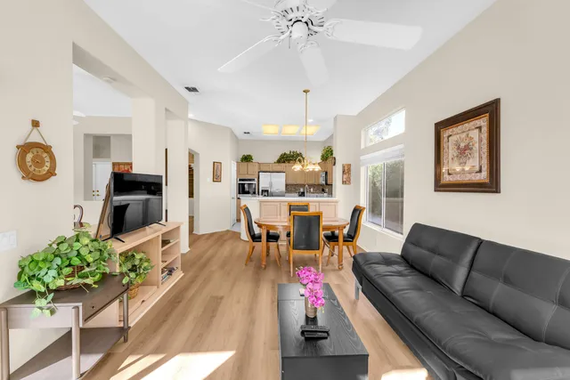 a view of a hallway with wooden floor and a living room