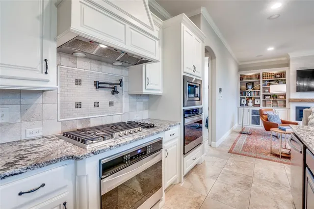 a kitchen with stainless steel appliances granite countertop a stove and a refrigerator