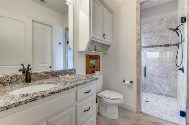 a bathroom with a granite countertop sink toilet and shower