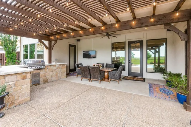 a view of a patio with table and chairs potted plants with the view of the house