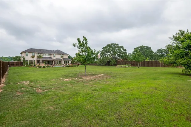 a view of a green field with house in the background
