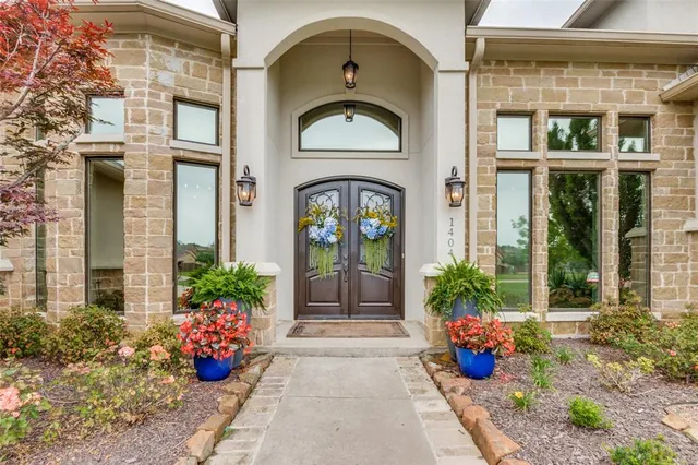a front view of a house with lots of potted plants