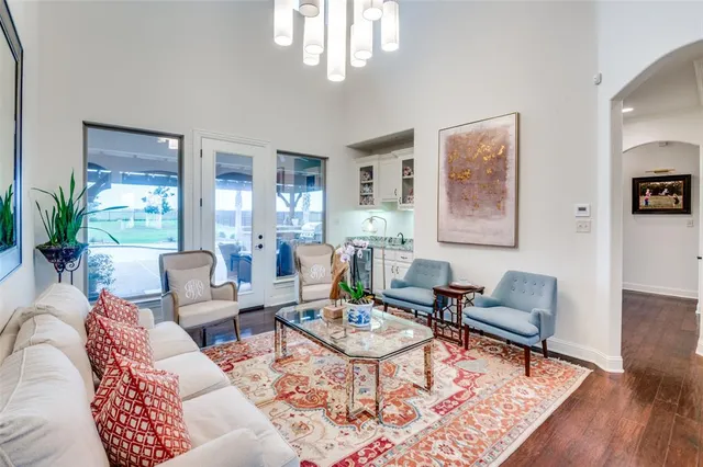 a living room with furniture a rug a lamp and a chandelier