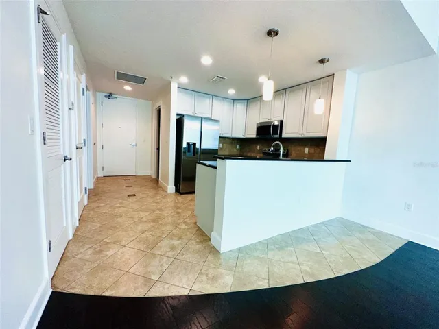 a bathroom with a granite countertop sink and a black white cabinet