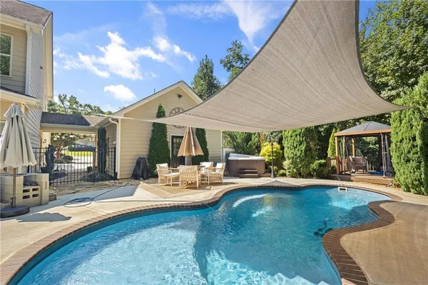 a view of a house with swimming pool and sitting area