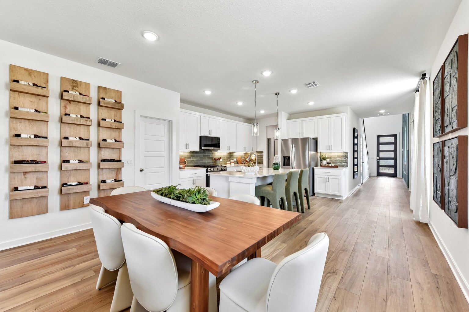 10609 Trifecta Way Buda, TX 78610 - Photo 13 of 17 A well-lit kitchen with sleek stainless steel appliances flows into a comfortable dining area with an adjacent wine display.