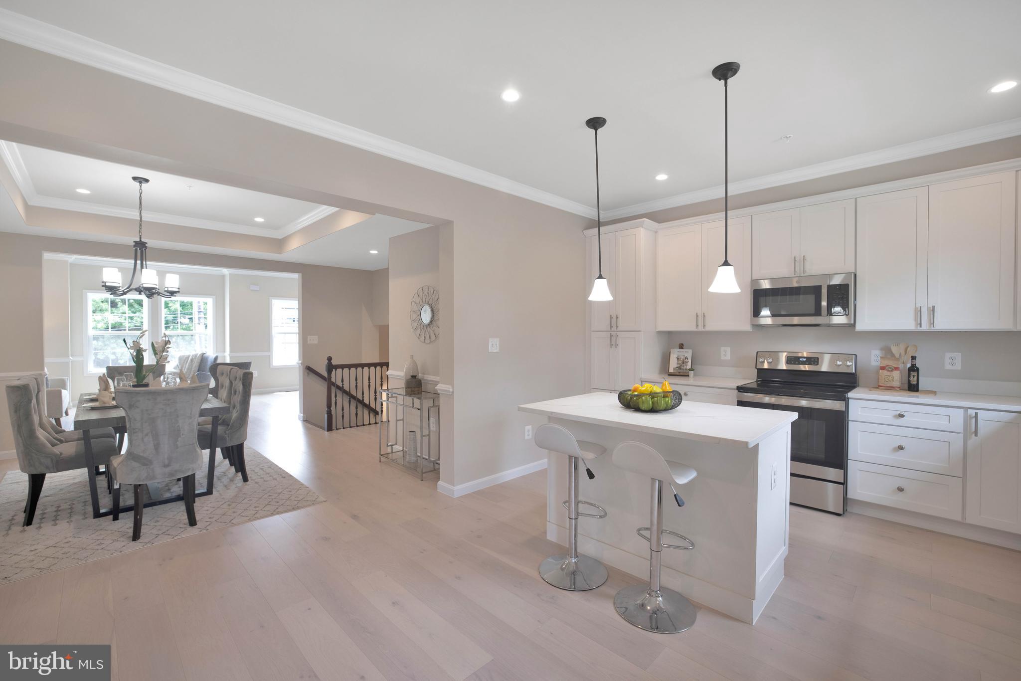 2417 Elvans Road Southeast Washington, DC 20020 - Photo 26 of 48 a kitchen with white cabinets and chairs