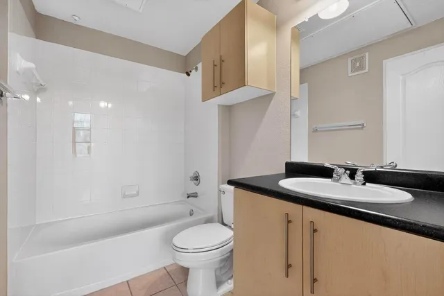 a bathroom with a granite countertop sink a toilet and a mirror