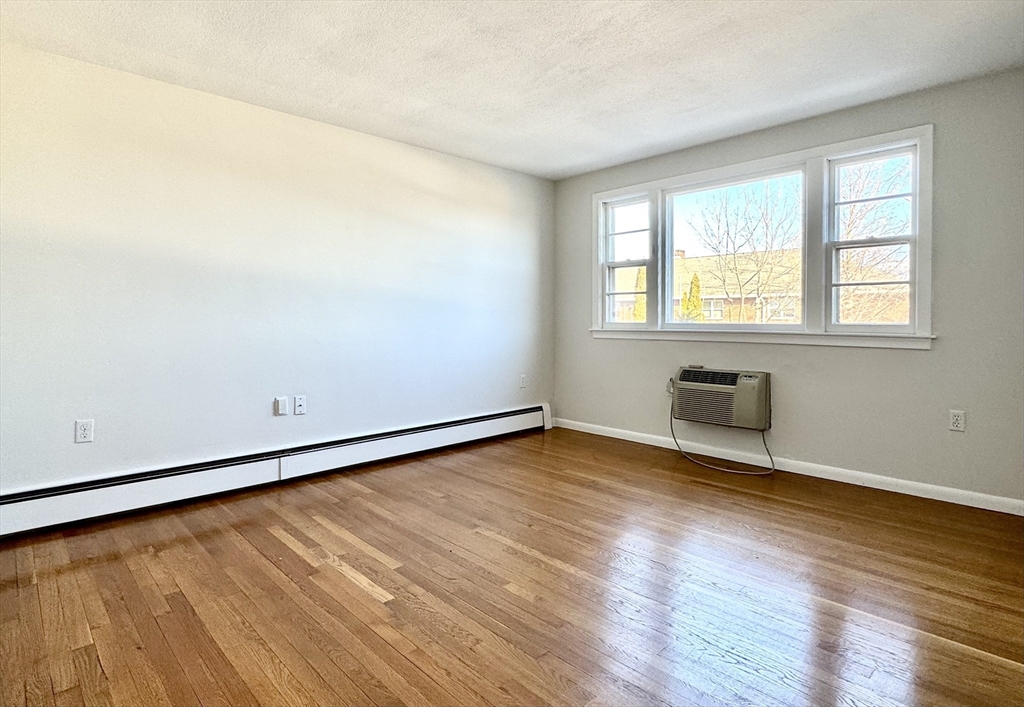 206 High Street, Unit 1 Waltham, MA 02453 - Photo 3 of 16 an empty room with wooden floor and windows