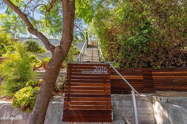 an aerial view of a house with a yard and trees all around