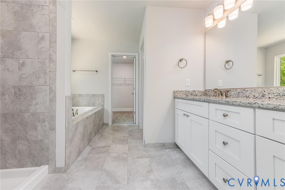 200 Victoria Drive Ruther Glen, VA 22546 - Photo 21 of 30 a bathroom with a granite countertop sink a mirror and a bathtub