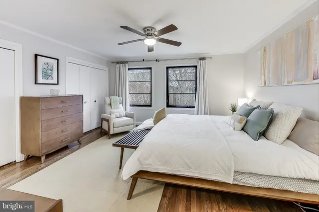 a bedroom with a large bed and windows