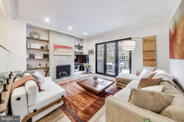 a living room with furniture fireplace and a large window