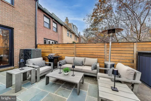a view of a patio with couches table and chairs with potted plants