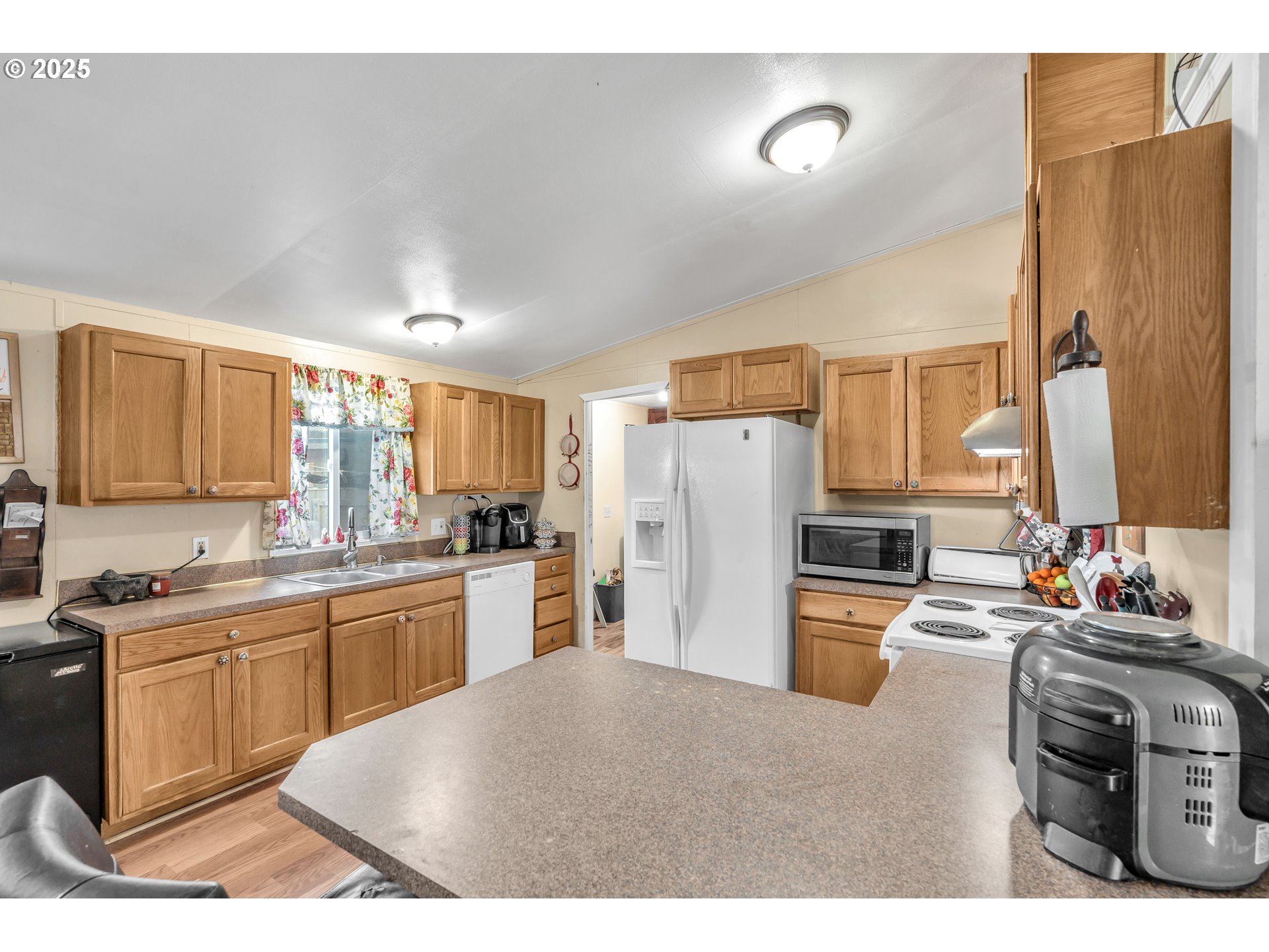 5885 Northeast Jacobson Street, Unit 70 Hillsboro, OR 97124 - Photo 9 of 29 a kitchen with a sink dishwasher a refrigerator and a stove with wooden floor
