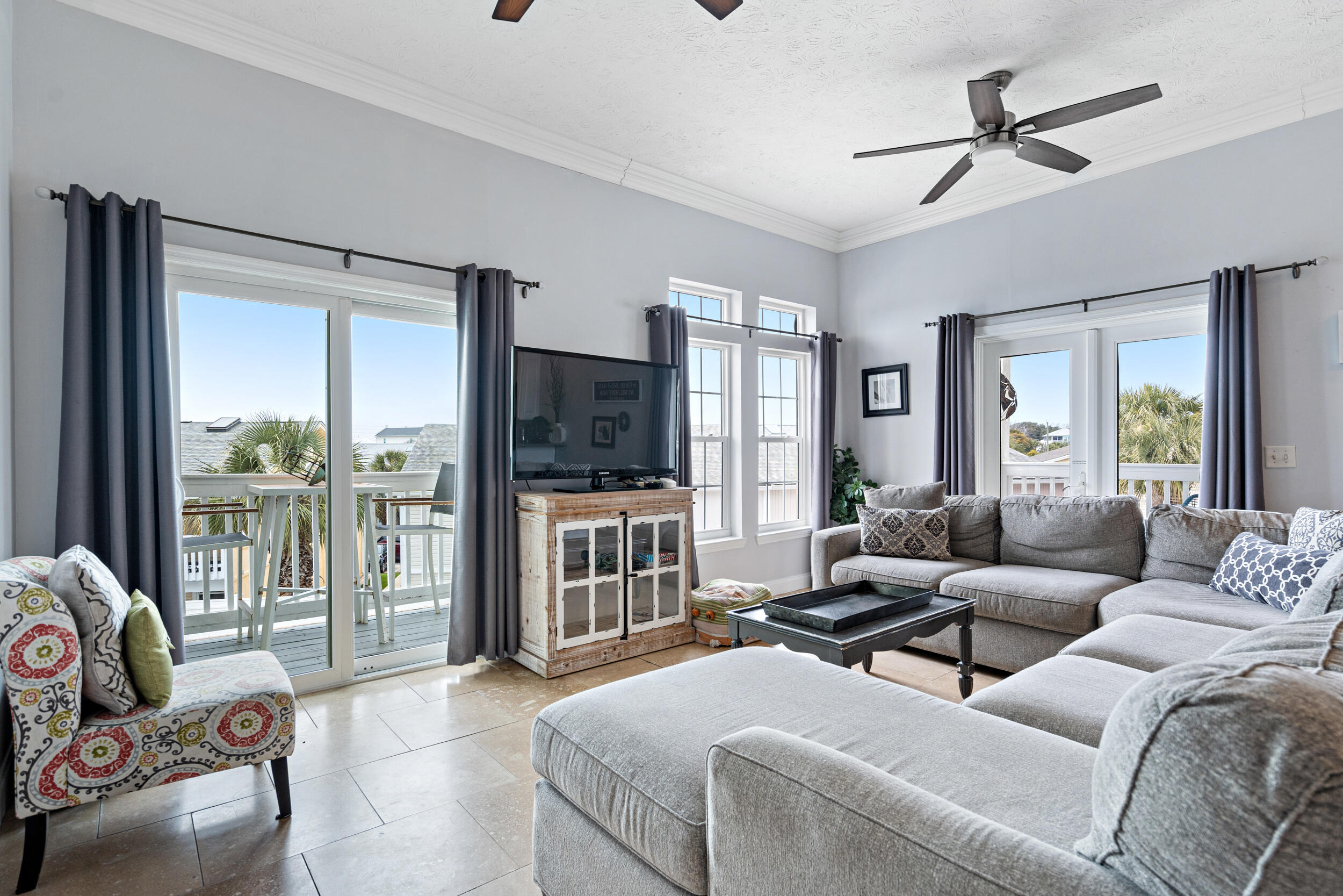 17878 Front Beach Road, Unit E2 Panama City Beach, FL 32413 - Photo 6 of 34 a living room with furniture a ceiling fan and a flat screen tv