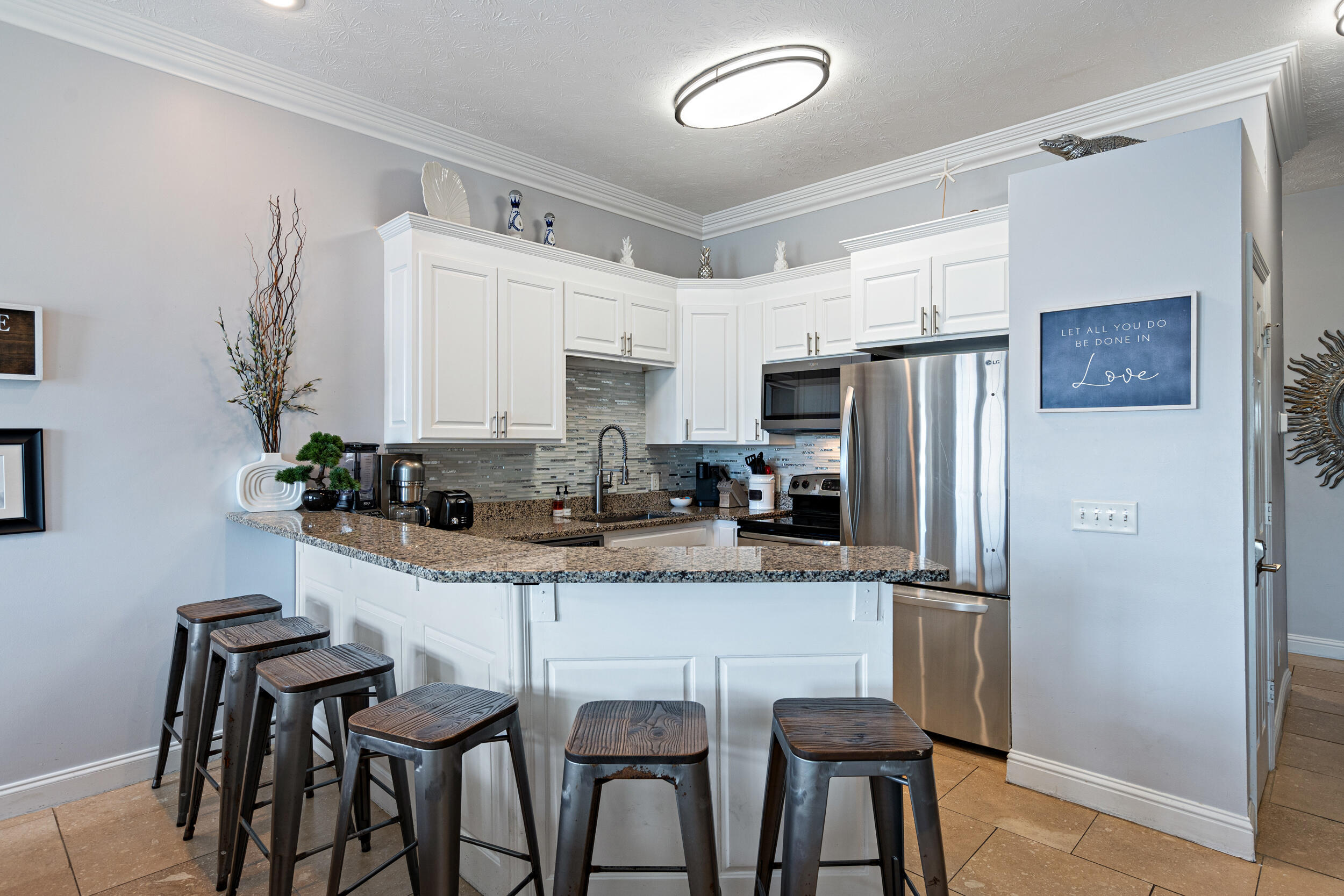 17878 Front Beach Road, Unit E2 Panama City Beach, FL 32413 - Photo 8 of 34 a kitchen with stainless steel appliances a dining table chairs refrigerator and sink