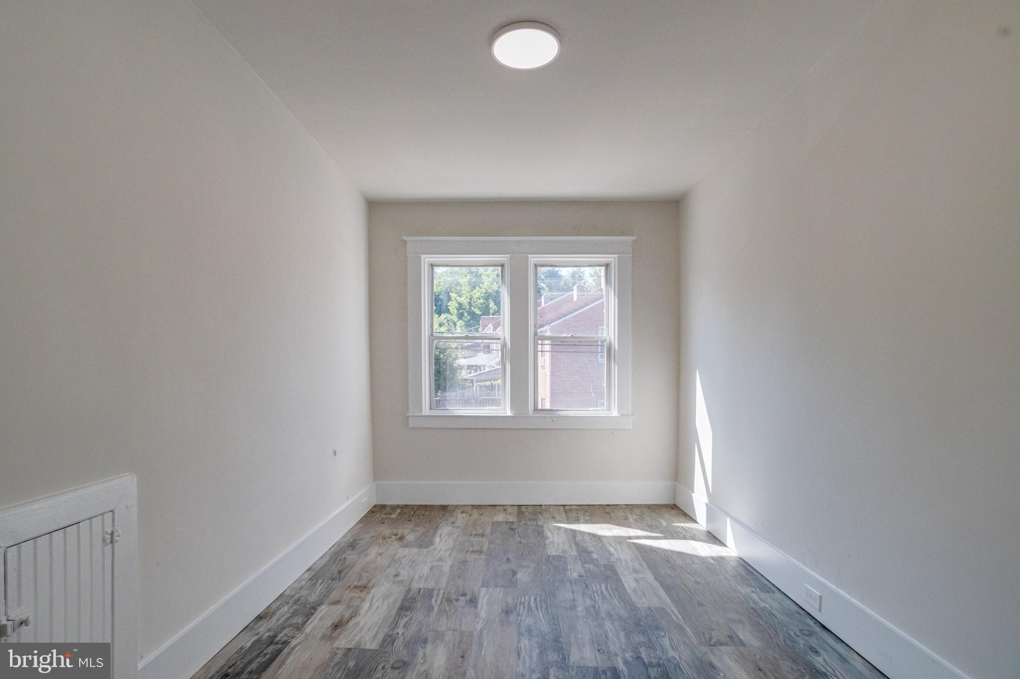 5878 Belair Road Baltimore, MD 21206 - Photo 23 of 41 an empty room with wooden floor and windows