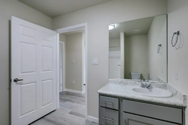 a bathroom with a granite countertop sink and a mirror