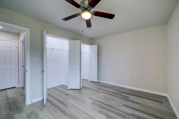 a view of empty room with wooden floor