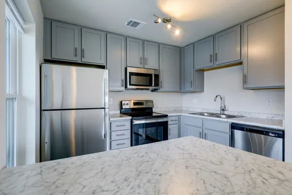 a kitchen with refrigerator a sink a stove a microwave and cabinets