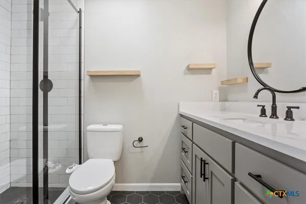a bathroom with a granite countertop sink toilet and shower