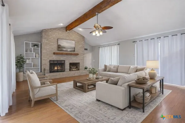 a living room with furniture a fireplace and a flat screen tv