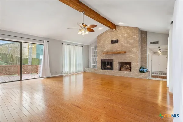 a view of an empty room with glass door and a window