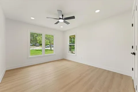 an empty room with windows and fan