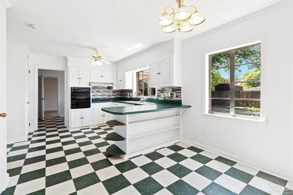 a kitchen with granite countertop white cabinets and black stainless steel appliances