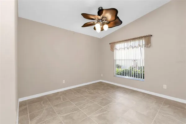 an empty room with a ceiling fan and windows