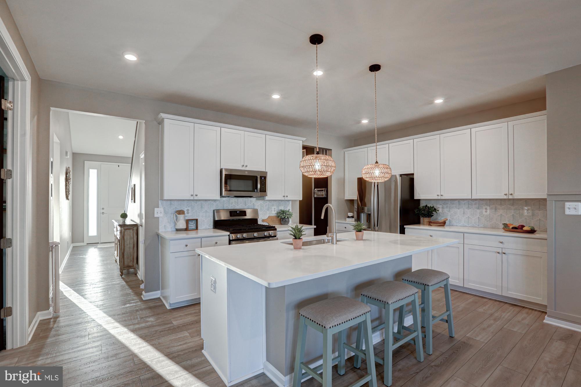 507 Cherry Bark Road Middletown, DE 19709 - Photo 17 of 81 a kitchen with stainless steel appliances a stove top oven a refrigerator a sink and white cabinets with wooden floor