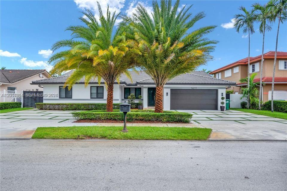 14211 Southwest 31st Street Miami, FL 33175 - Photo 1 of 27 a front view of a house with a garden and trees