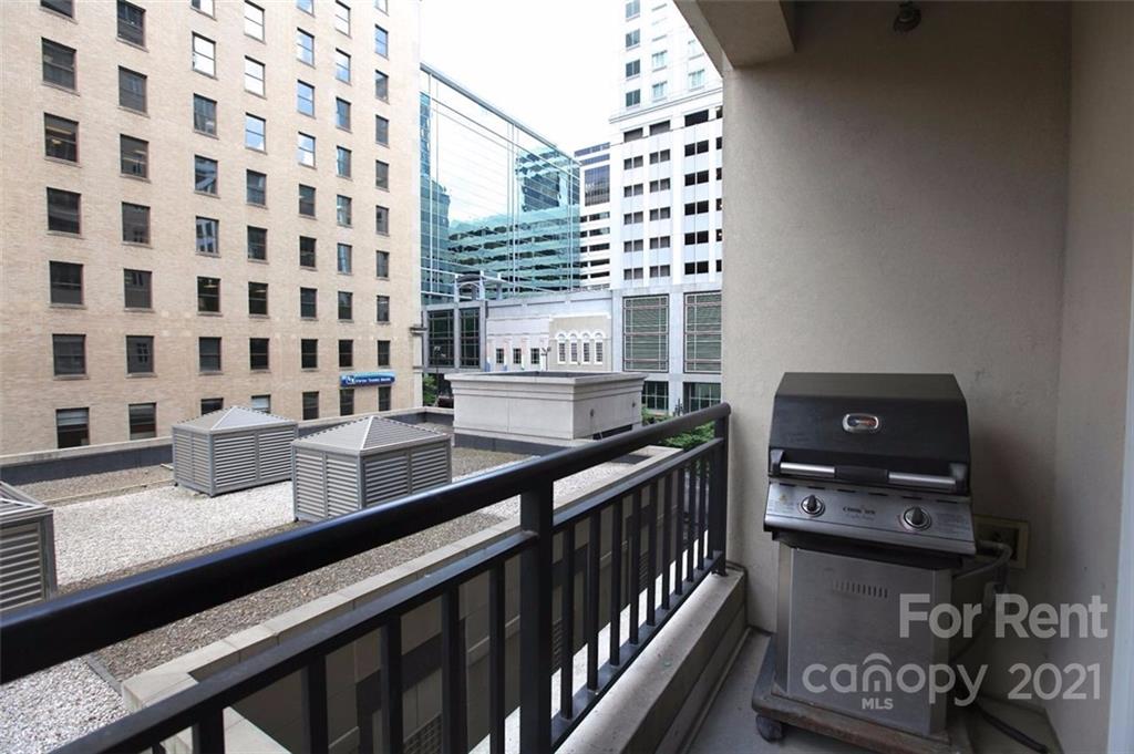 230 South Tryon Street, Unit 304 Charlotte, NC 28281 - Photo 16 of 17 a view of a balcony with wooden floor and bench