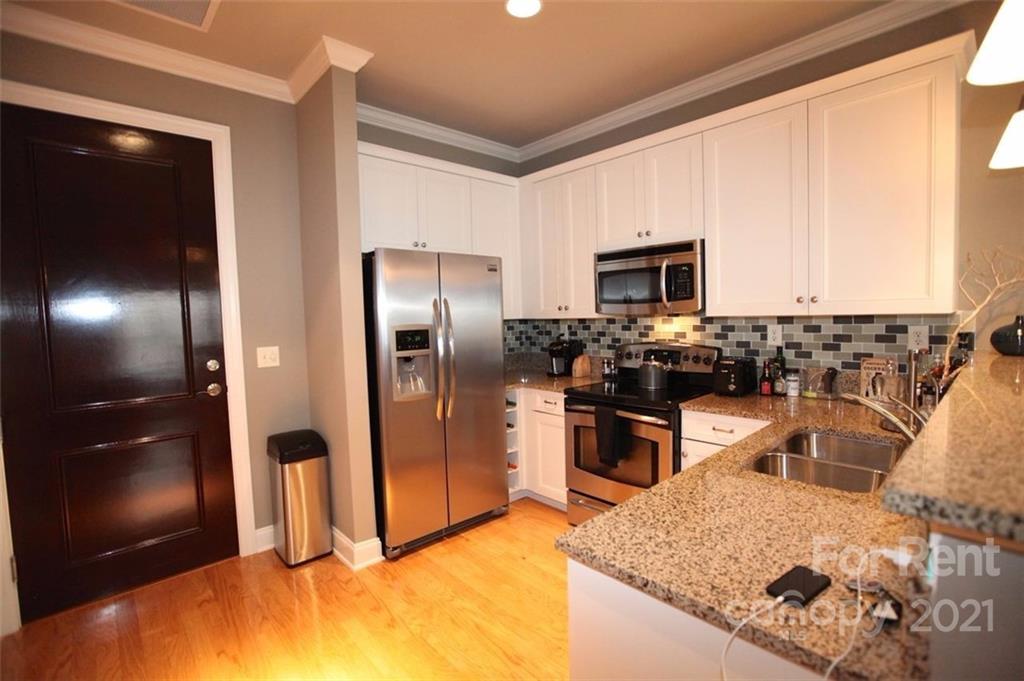 230 South Tryon Street, Unit 304 Charlotte, NC 28281 - Photo 2 of 17 a kitchen with stainless steel appliances granite countertop a sink stove and refrigerator