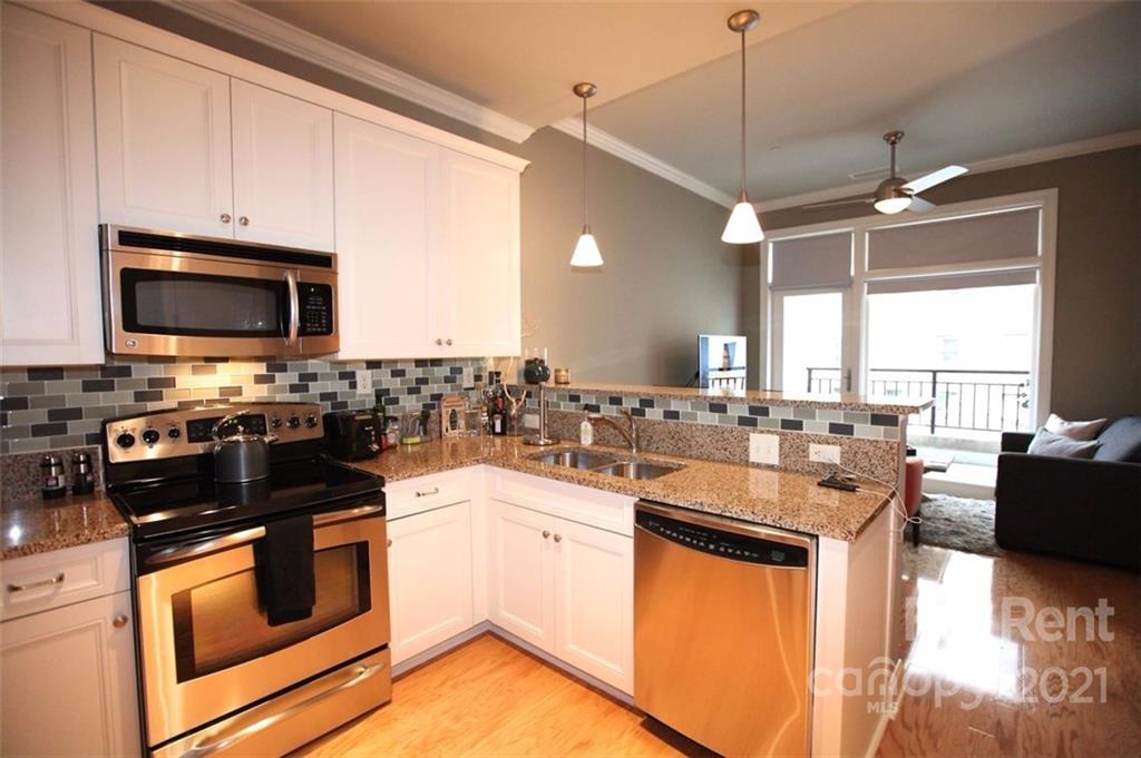 230 South Tryon Street, Unit 304 Charlotte, NC 28281 - Photo 4 of 17 a kitchen with a sink stove and microwave