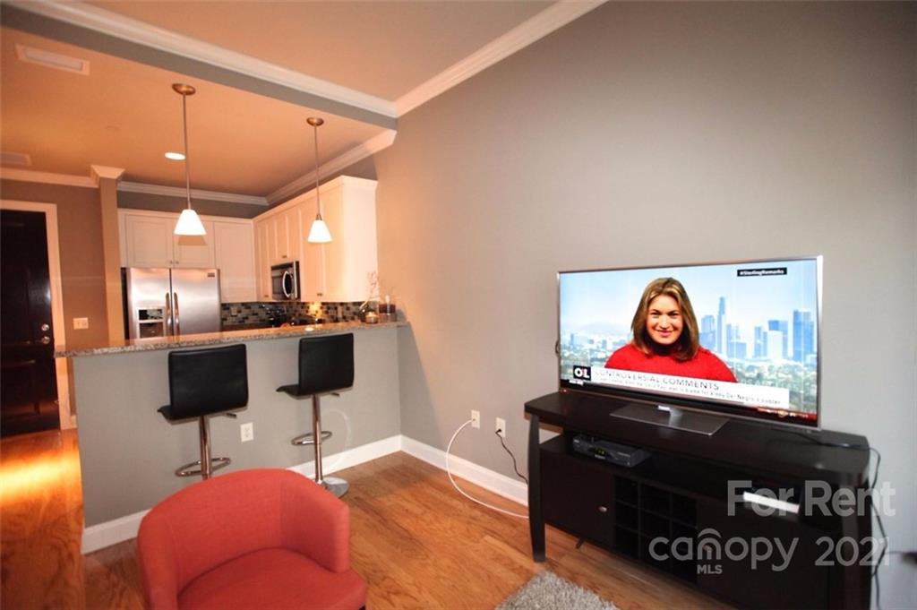 230 South Tryon Street, Unit 304 Charlotte, NC 28281 - Photo 7 of 17 a living room with furniture and a flat screen tv