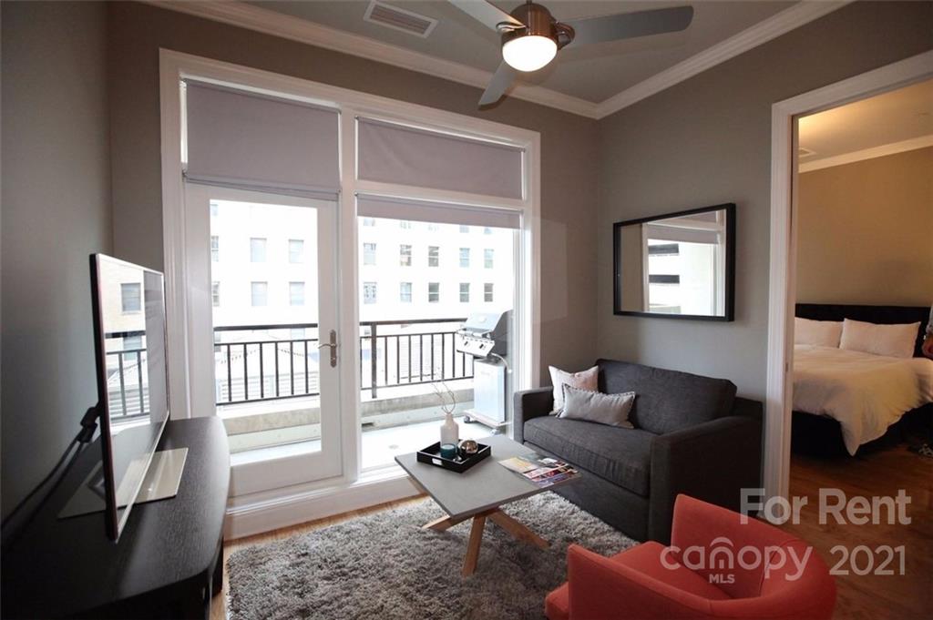 230 South Tryon Street, Unit 304 Charlotte, NC 28281 - Photo 8 of 17 a living room with furniture and a window
