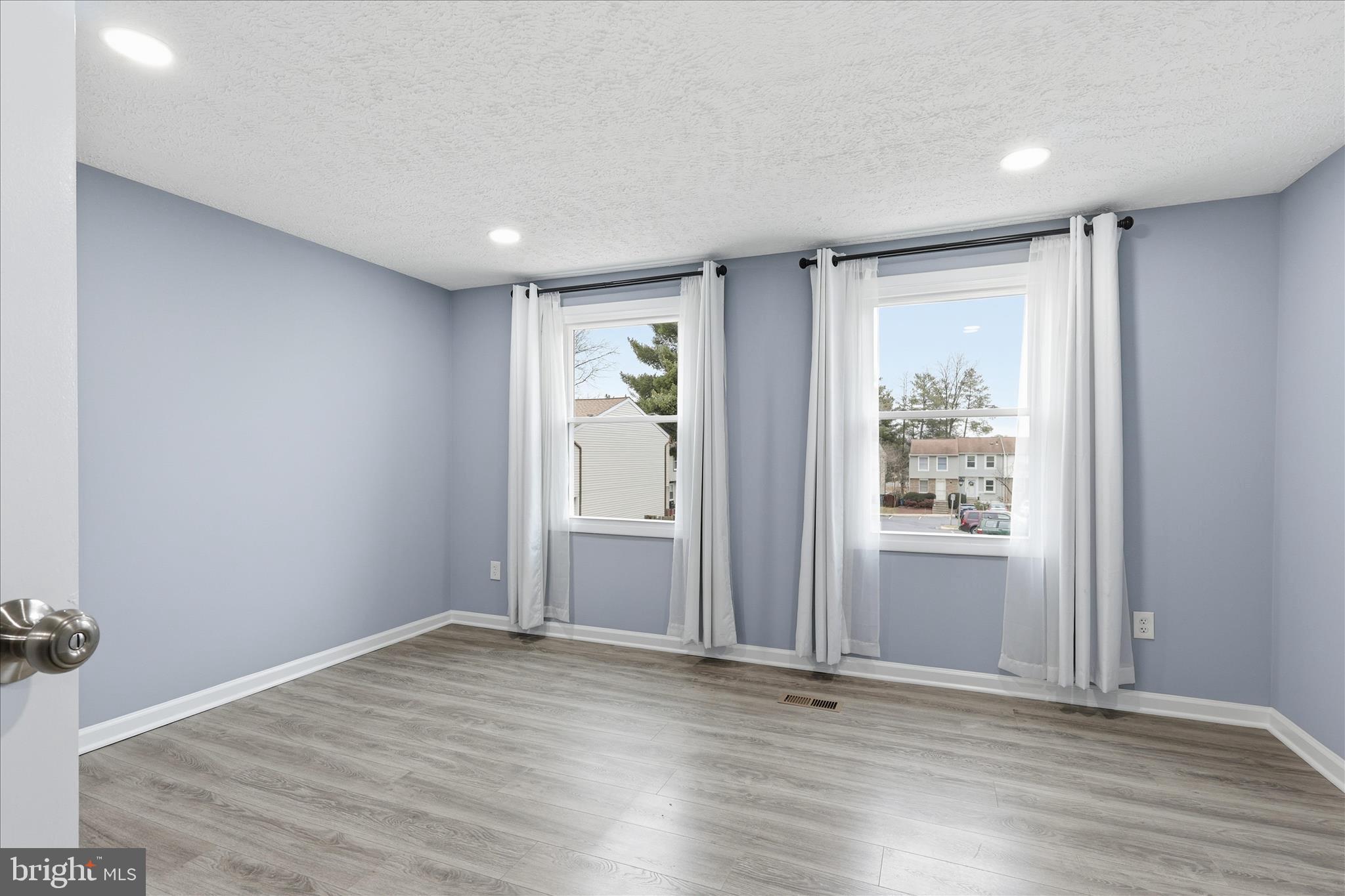 307 Brethour Court Sterling, VA 20164 - Photo 13 of 43 an empty room with wooden floor and windows
