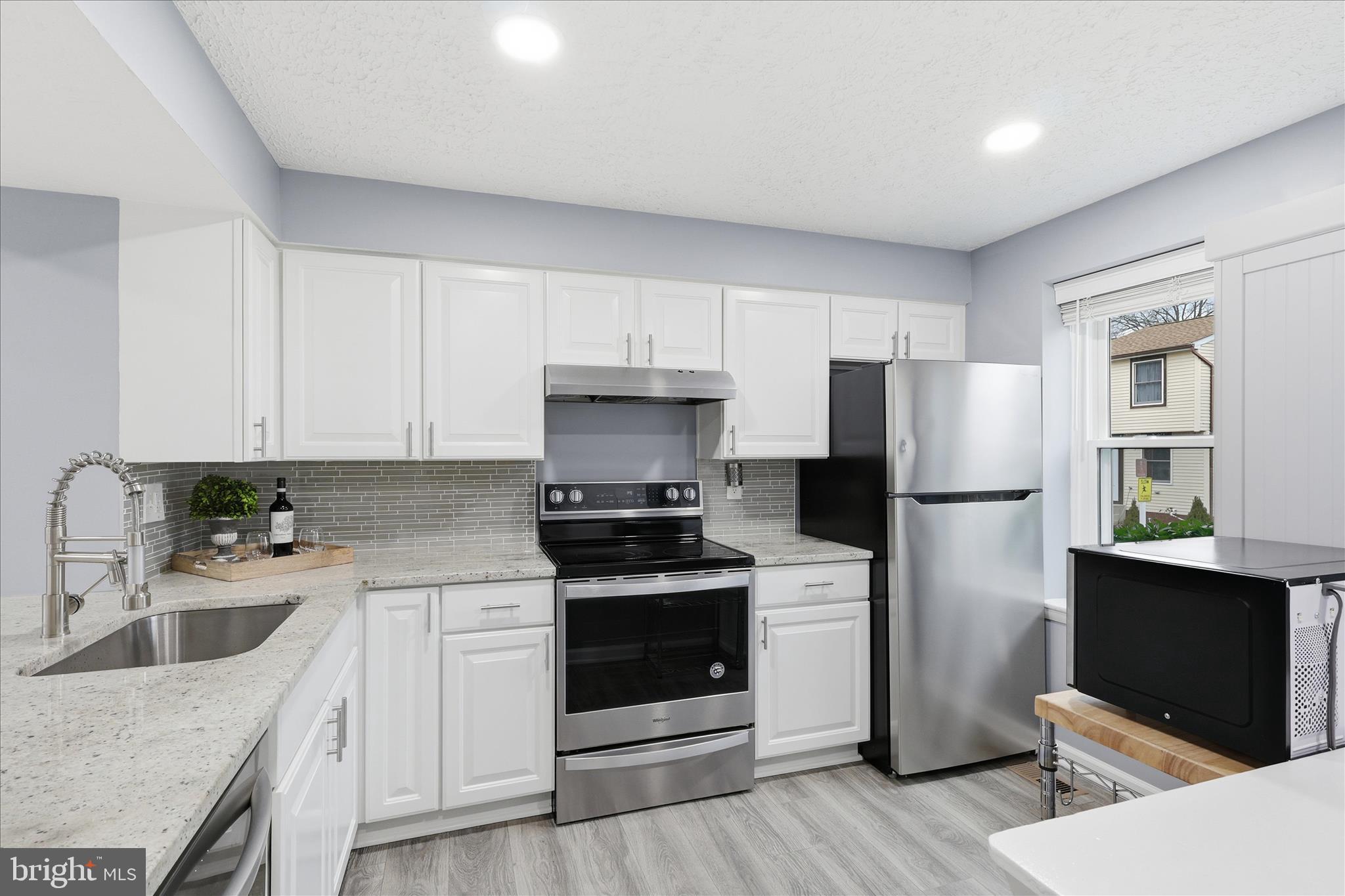307 Brethour Court Sterling, VA 20164 - Photo 6 of 43 a kitchen with a sink a stove a refrigerator and cabinets