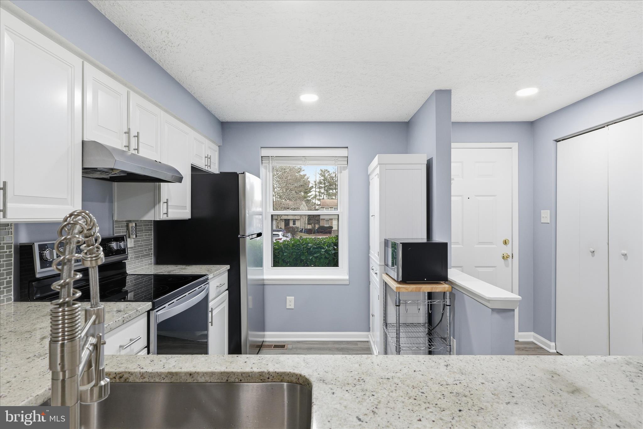 307 Brethour Court Sterling, VA 20164 - Photo 7 of 43 a kitchen with stainless steel appliances kitchen island granite countertop a refrigerator and a sink